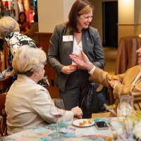 Laura Aikens in conversation with three event guests sitting at table